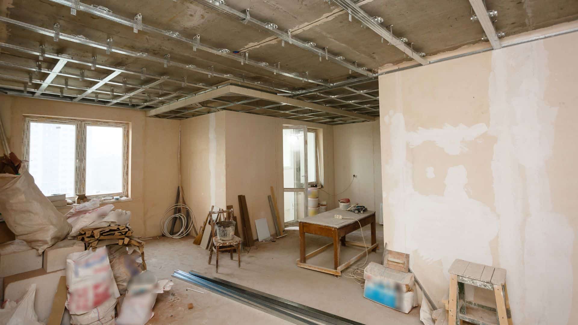 Renovierungsarbeiten in einem Innenraum, Betondecke und frisch verputzte Wände, Ausbau und Sanierung, Handwerksarbeit, Baustelle für Haus- oder Wohnungssanierung.