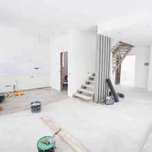 Abbildung eines modernen, renovierten Innenbereichs mit offener Treppe und Bauarbeiten, die eine hochwertige Sanierung zeigen.