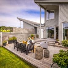 Helle Terrasse mit modernem Design, gemütlicher Sitzgruppe und Blick auf den Garten, ideal für outdoor Entspannung und gesellige Abende.